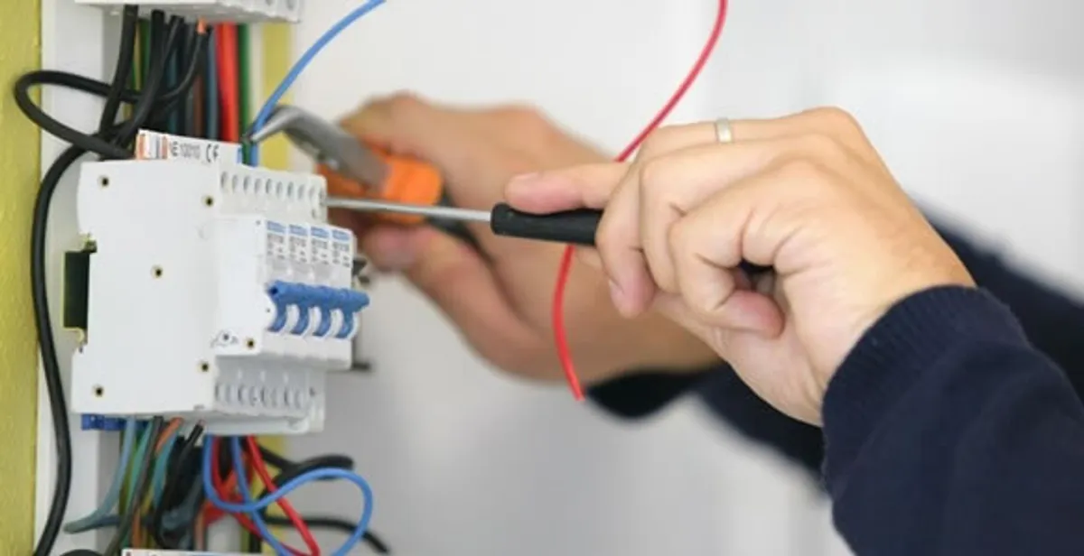 Electrician installing and adjusting circuit breakers in an electrical panel in Boca Raton, FL