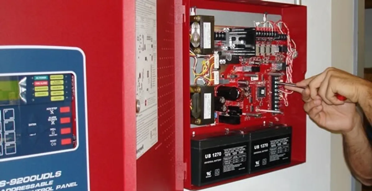 fire alarm installation service showing technician configuring fire alarm control panel in Boca Raton, FL