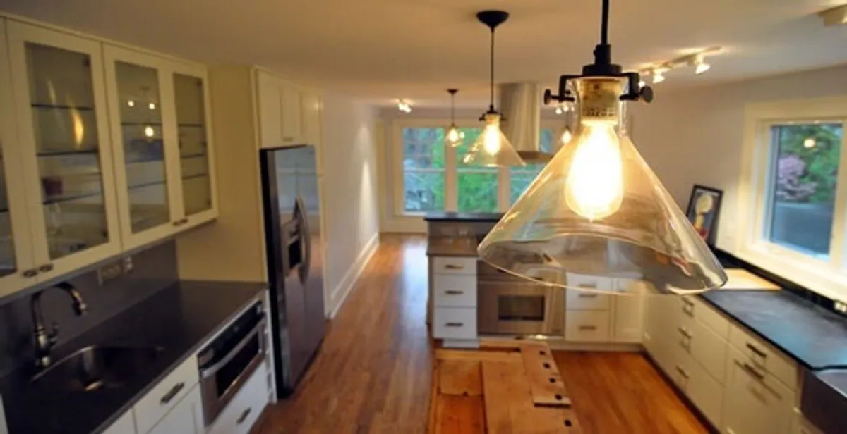 Residential electrician installing modern indoor light fixture in a home in Boca Raton, FL